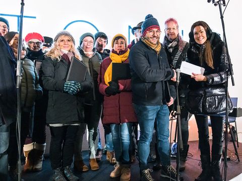 Geschäftsführerin Miriam Häring steht auf der Bühne mit dem Gesangsverein Kinderchor